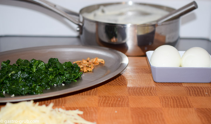 Ingredients for gratinee: mornay sauce, hard boiled eggs, sauteed spinach, browned garlic, and Jarlsberg cheese.