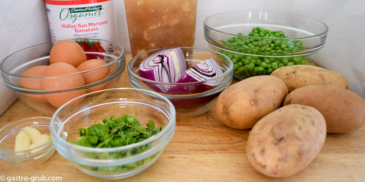 Ingredients for Italian stew: tomatoes, chicken stock, peas, potatoes, onion, garlic, parsley, basil, and eggs.