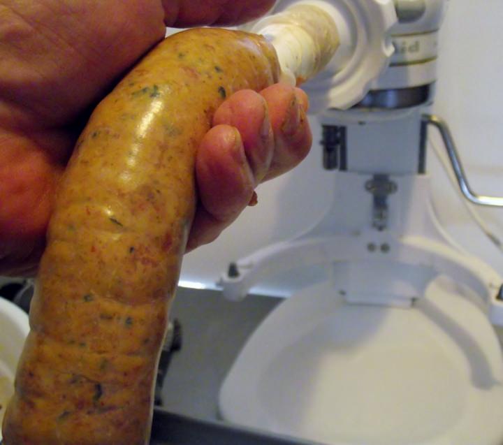 Sausage being stuffed into hog casing.