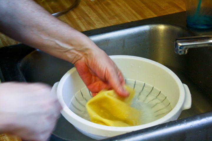 Cooked pasta sheets in an ice bath.