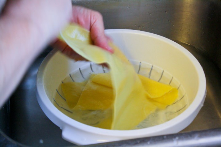 Cooked pasta sheets in an ice bath.