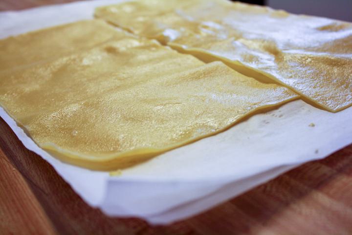 Cooked pasta sheets drying on a tea towel.