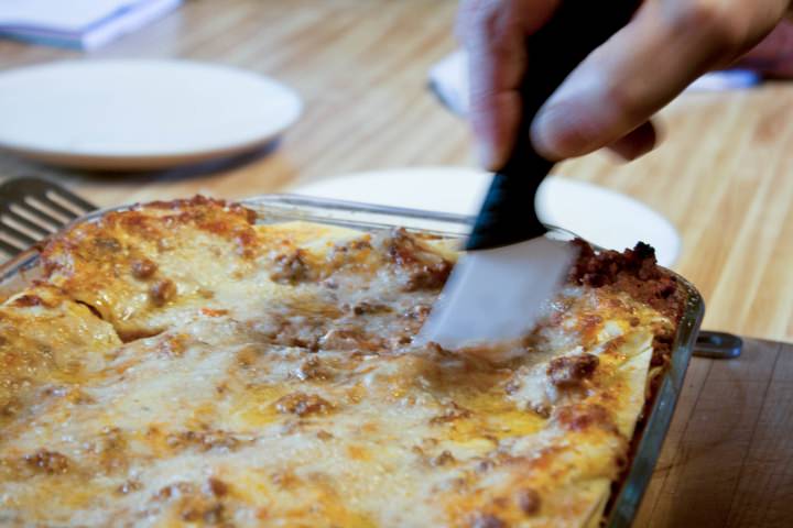 Cutting the finished lasagna bolognese.