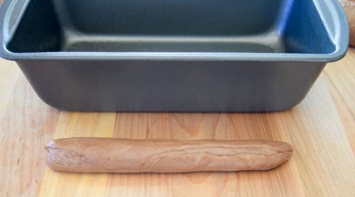 Measuring the dough length against the bread pan.