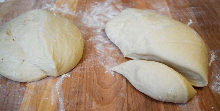 Bread dough on a pastry board, divided.