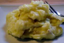 All butter mashed potatoes, on a plate, with a fork.