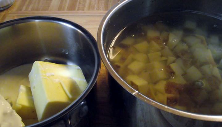 Diced potatoes in a saucepan and cream and butter in another saucepan.