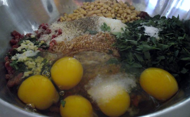 Ingredients for meatballs in a mixing bowl.