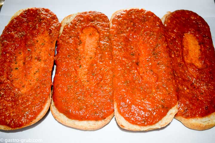 Spreading the marinara on the bread.