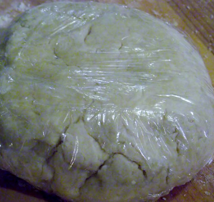 Pastry crust wrapped in plastic wrap.