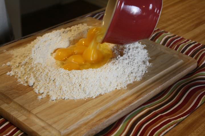 Adding eggs to a flour well for pasta
