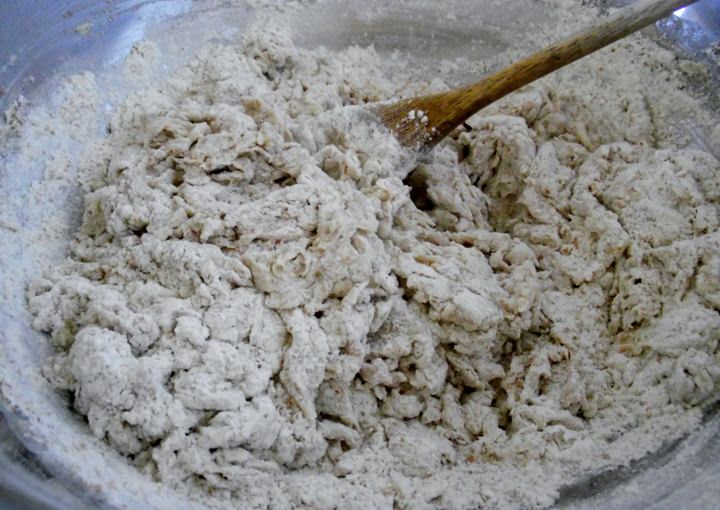 Pizza dough just coming together in a mixing bowl.