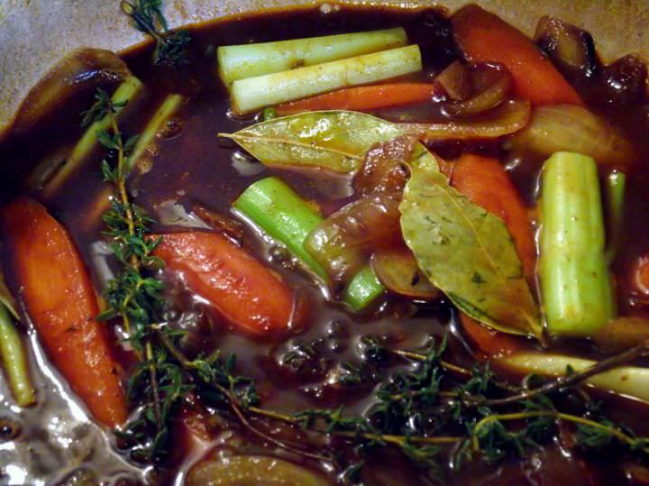 All the vegetables, herbs, spices, and wine are added to the braising pot.
