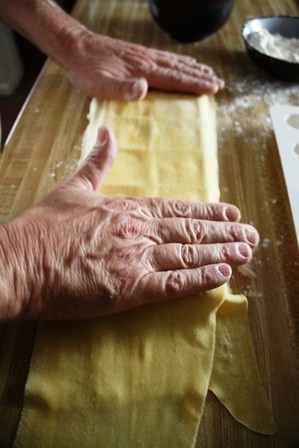 Covering raviolis with second pasta sheet.