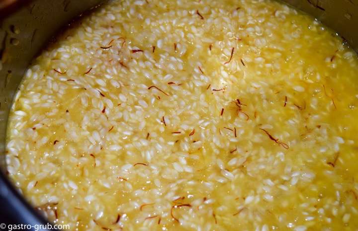 The rice, wine, and saffron in a pot.