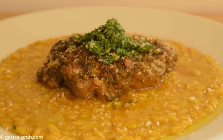Risotto Milanese with osso buco, on a plate.