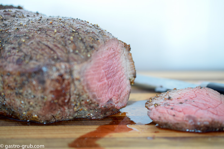 Roast beef with the end sliced off, showing the pink color of the rare meat.