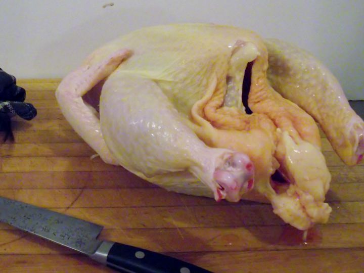 A whole chicken on a cutting board.