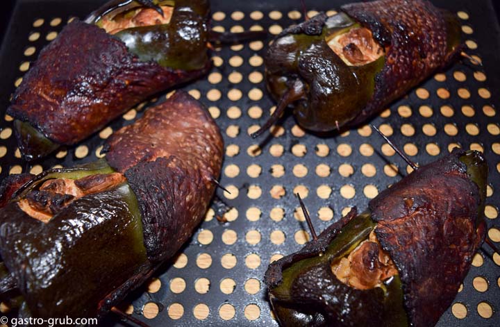 Smoked chile rellenos on a perforated grill pan.