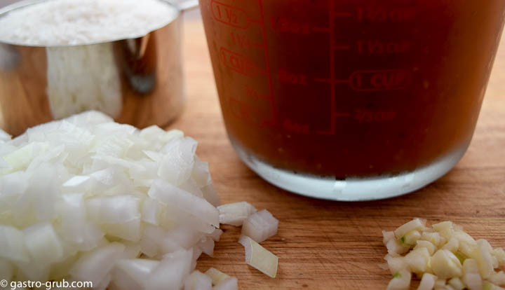 Ingredients for Spanish rice: medium grain white rice, tomato puree, chicken stock, onions, and garlic.