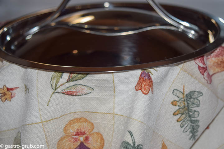 Spanish rice in a pot with a lint free towel between the pot and the lid.