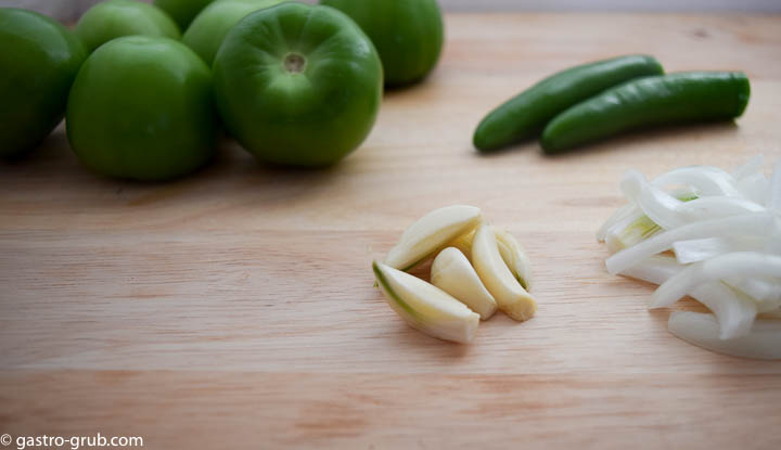 Mise en place, or ingredients for tomatillo sauce: tomatillos, serrano chilies, onions, and garlic.