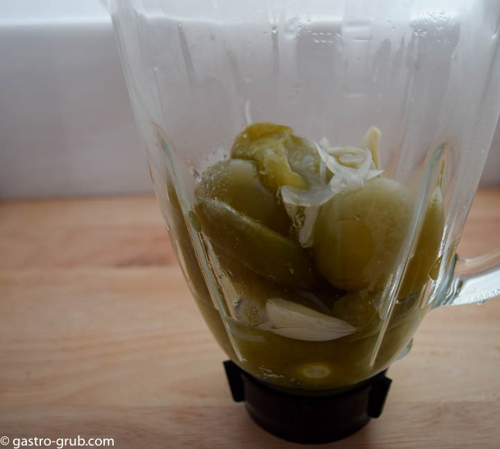 Cooked ingredients for tomatillo sauce in a blender jar.