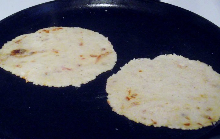 Tortillas cooking on a comal