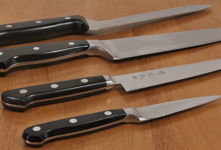 Essential kitchen knives: bread knife, chef's knife, utility knife, and a paring knife.