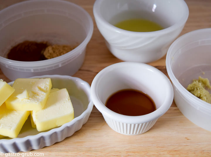 Ingredients for country apple pie: cinnamon, allspice, ground ginger, lemon juice, grated ginger, vanilla, and butter.