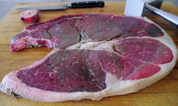 Round steak on a cutting board with the bone removed.