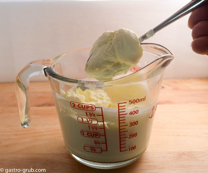 Mexican crema in a measuring cup.