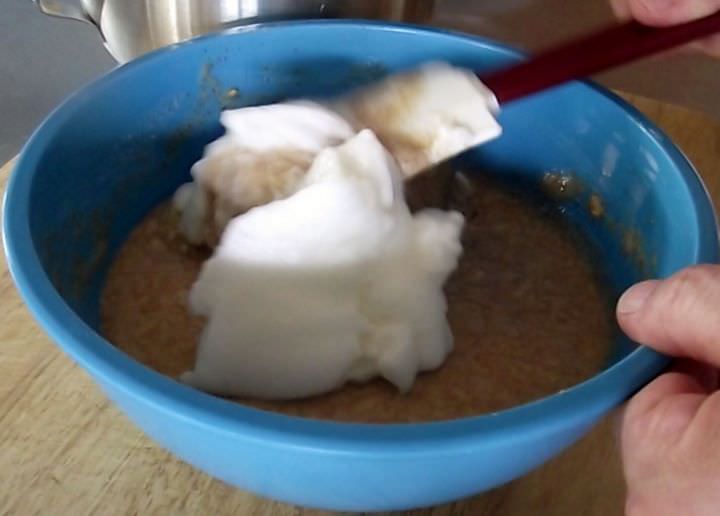 Folding egg whites into waffle batter.