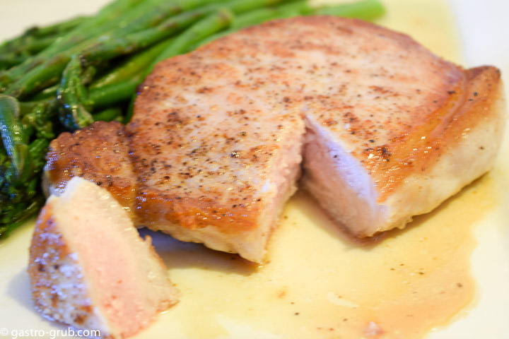 Pork chop and asparagus on a plate.