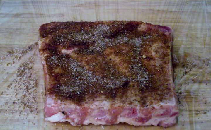 Pork rib section coated with dry rub.