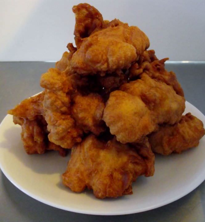 Sfinge or zeppole di San Giuseppe stacked on a plate.