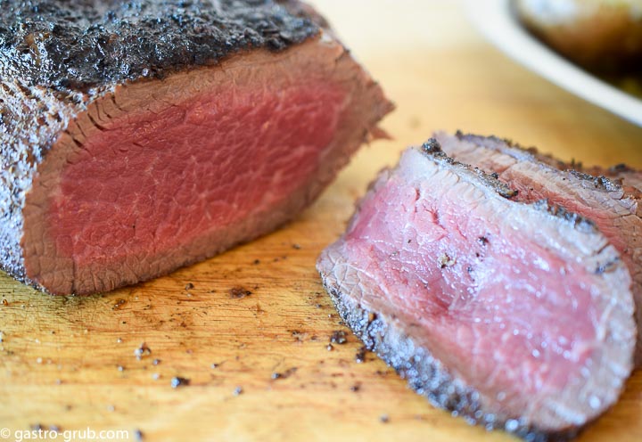 Tri tip roast slices showing the temperature and grain.